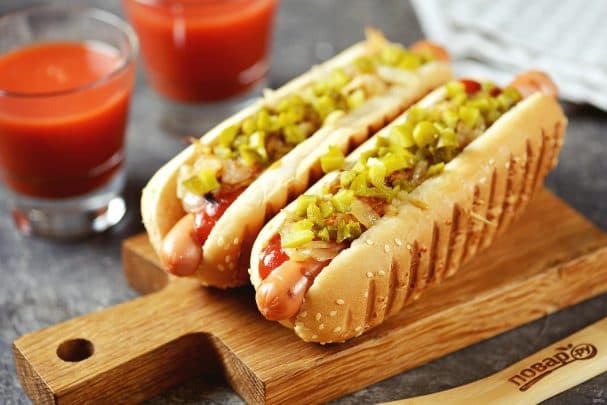 Хот-дог с жареным луком и солёными огурцами на сковороде